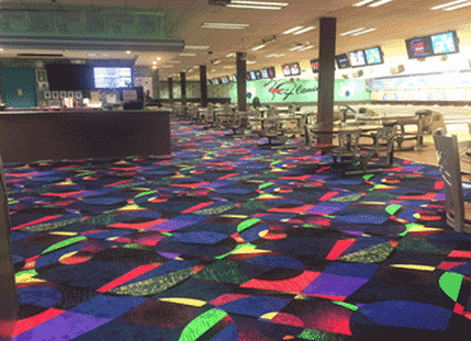 Flamingo Bowl's newly renovated concourse with its bright multicolored cosmic carpet, tables, and lanes with video displays.